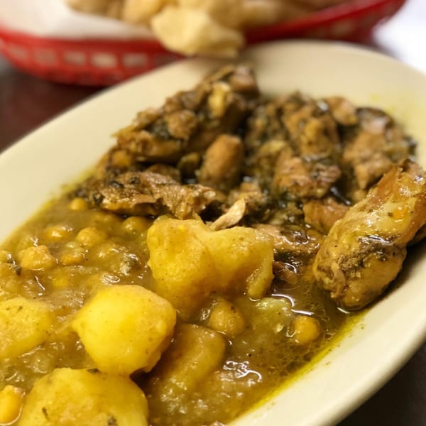 Close-up of Pam's Caribbean Kitchen's curry chicken and potatoes in a white dish.