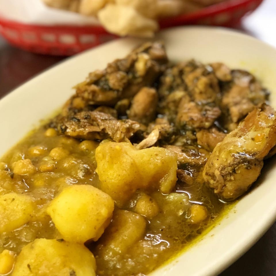 Close-up of Pam's Caribbean Kitchen's curry chicken and potatoes in a white dish.